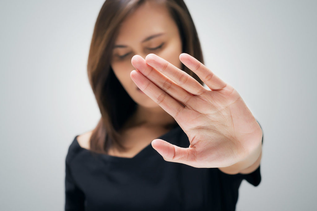 woman putting her hand up knowing How To Stop Drug Abuse