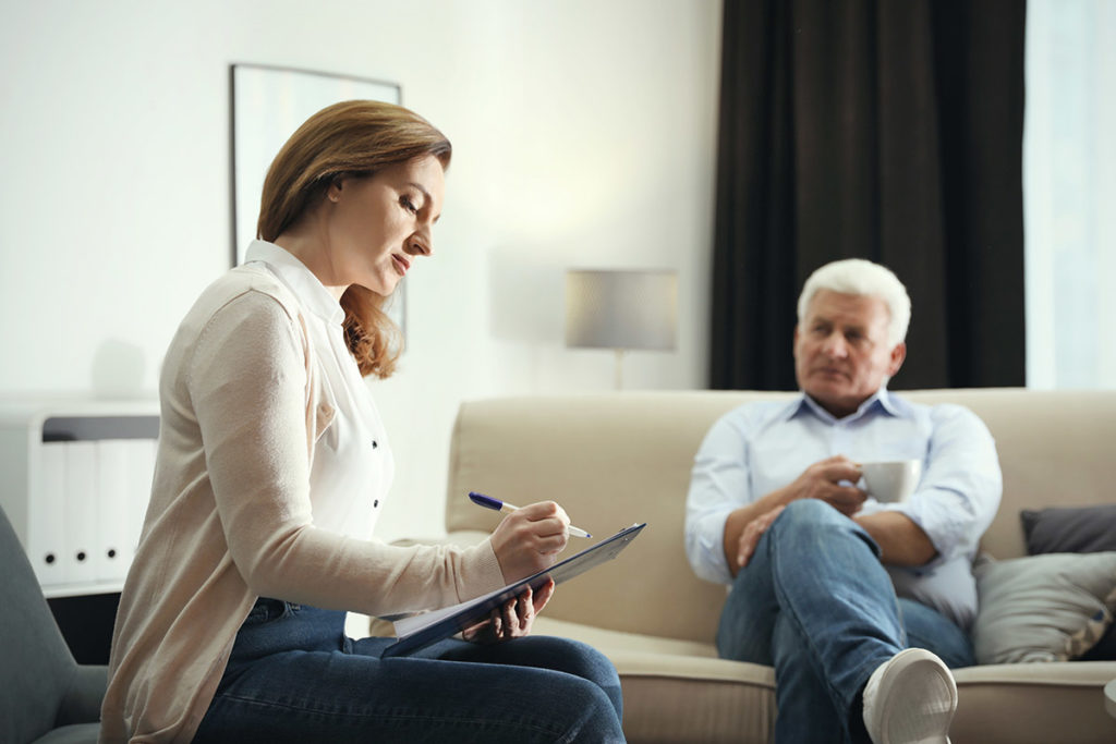 Psychiatrist vs Therapist taking notes during man's therapy session