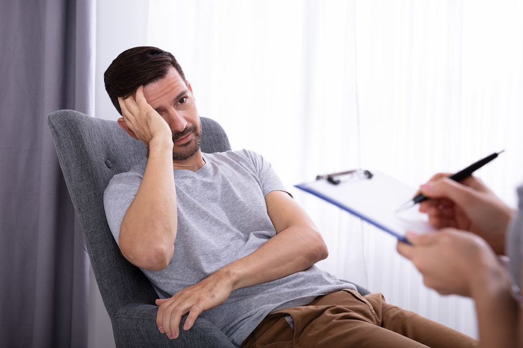 man struggling with emotions in therapy asking Will I Need Extended Rehab Care