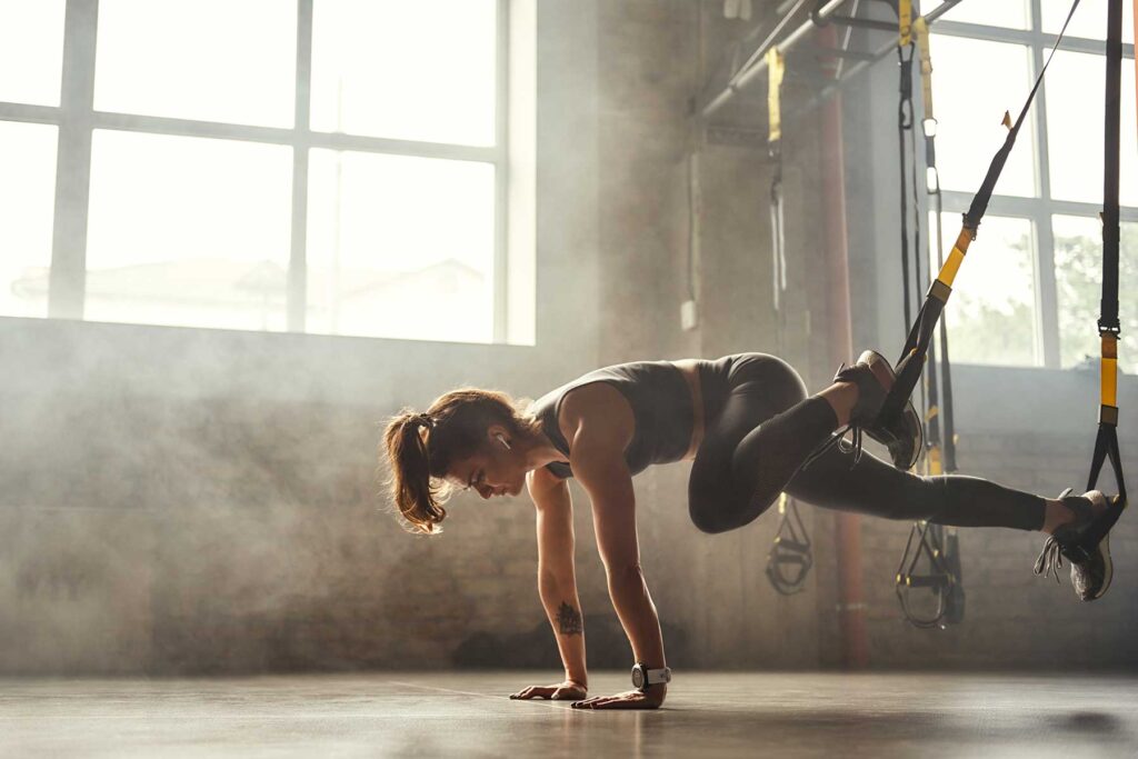 Person at gym overexerting herself while struggling with extreme fitness and eating disorders