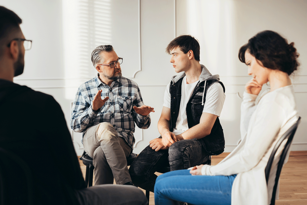 People in group therapy receiving peer support in a 12-step program