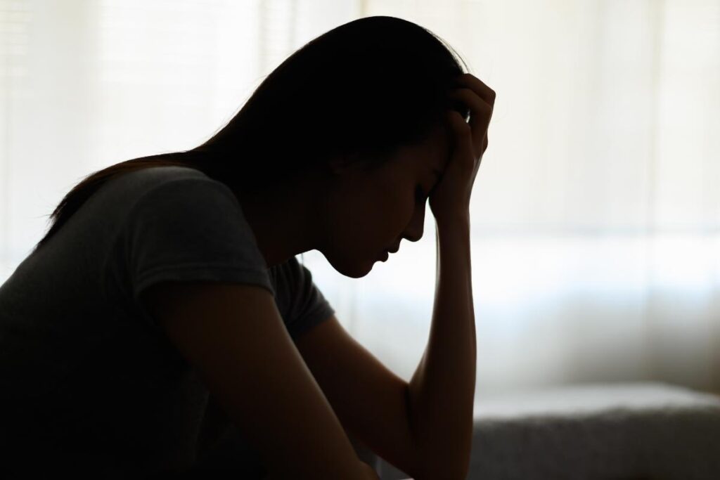 Silhouette of sad person experiencing PTSD from rape