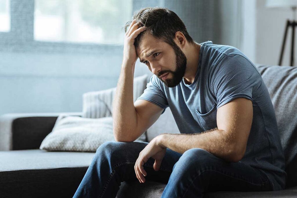 a man sits on his bed and considers stress in armed service members