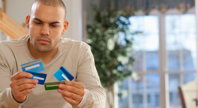 Man looking at several credit cards