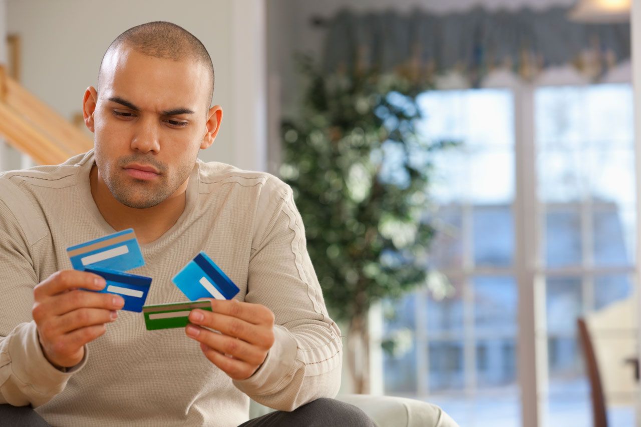 Man looking at several credit cards