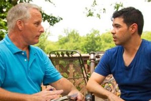 Two men sit facing each other having a therapeutic discussion