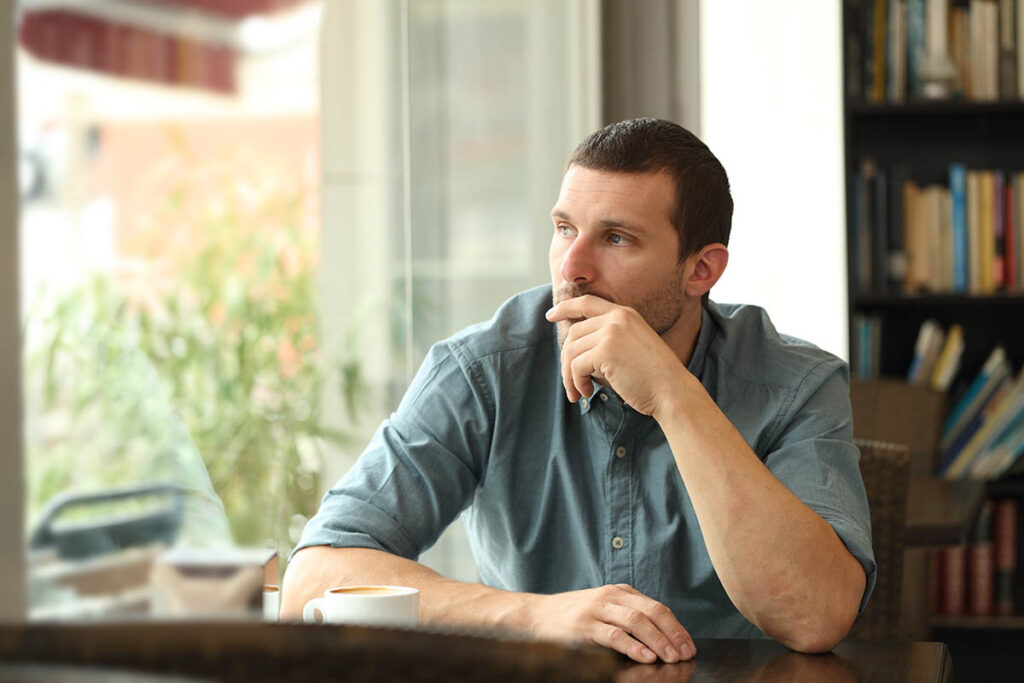 Person looking out of cafe window wondering if he has personality quirks or disorder
