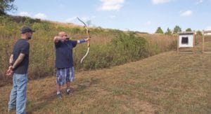 two men with bow and arrow doing archery therapy programs at the ranch for addiction and mental health