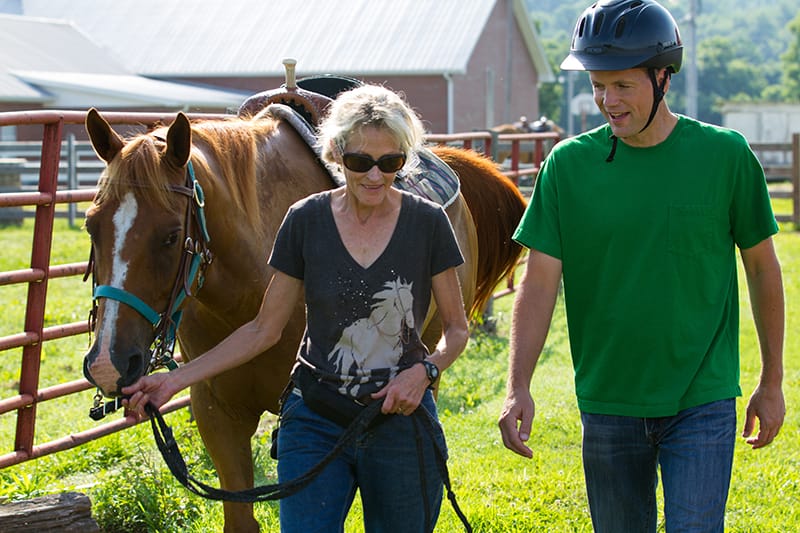 Man and woman participating in equine therapy rehab center photo gallery