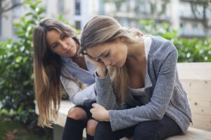 two women on a bench outside of a mental health treatment center