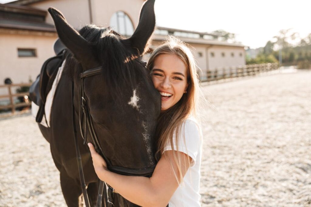 young woman hugging a horse on a ranch participating in equine assisted psychotherapy