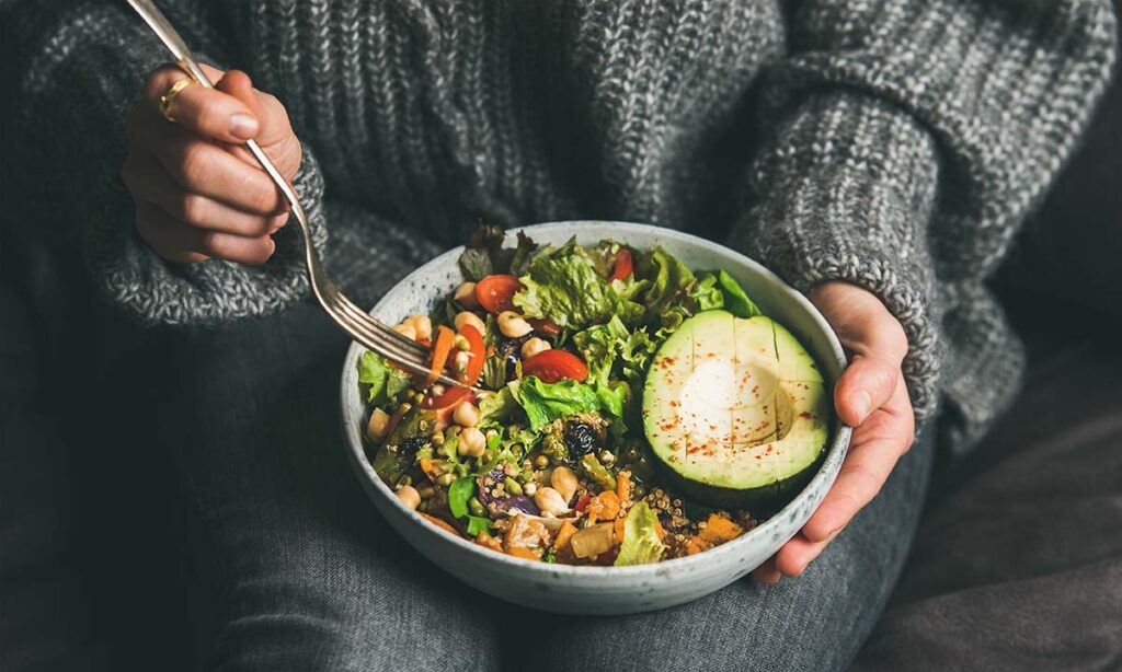 Person eating salad as an example of healthy foods for addiction recovery
