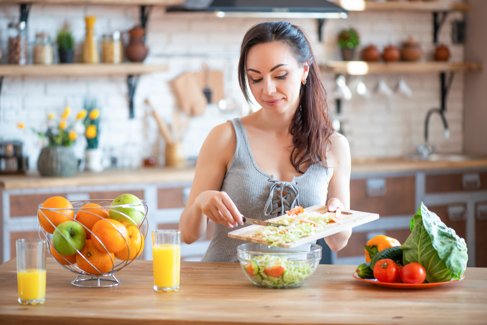 Woman prepping healthy food after addiction treatment and recovery