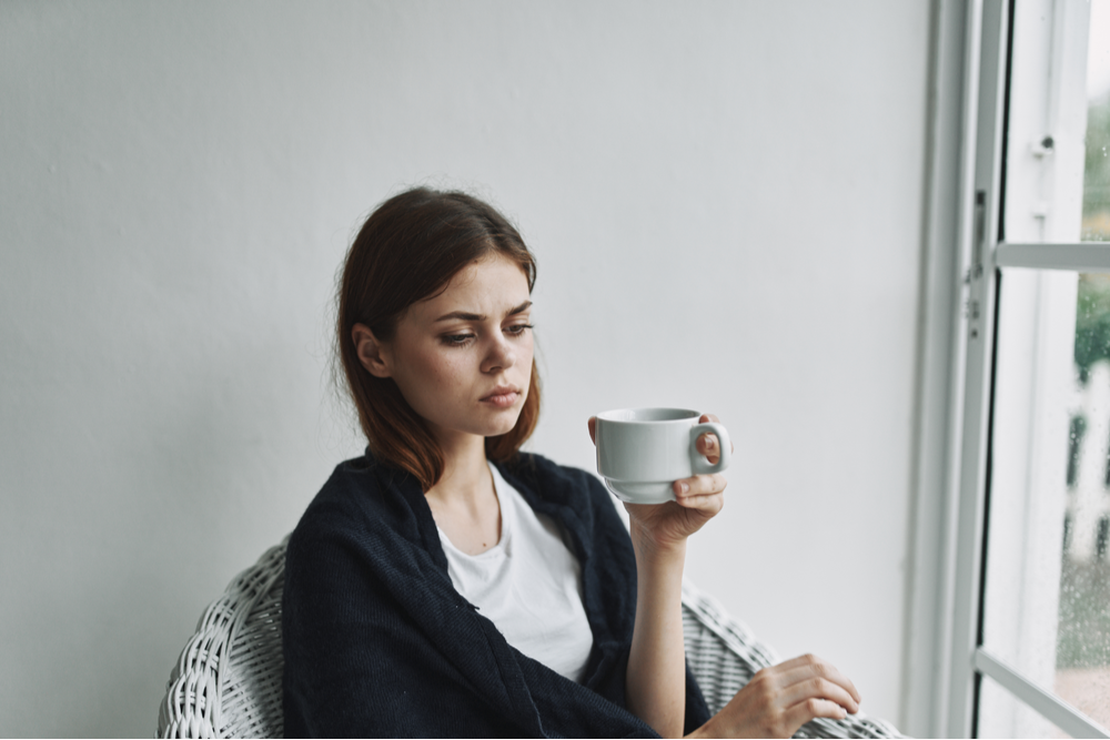 Woman drinking coffee worried about her mood disorder