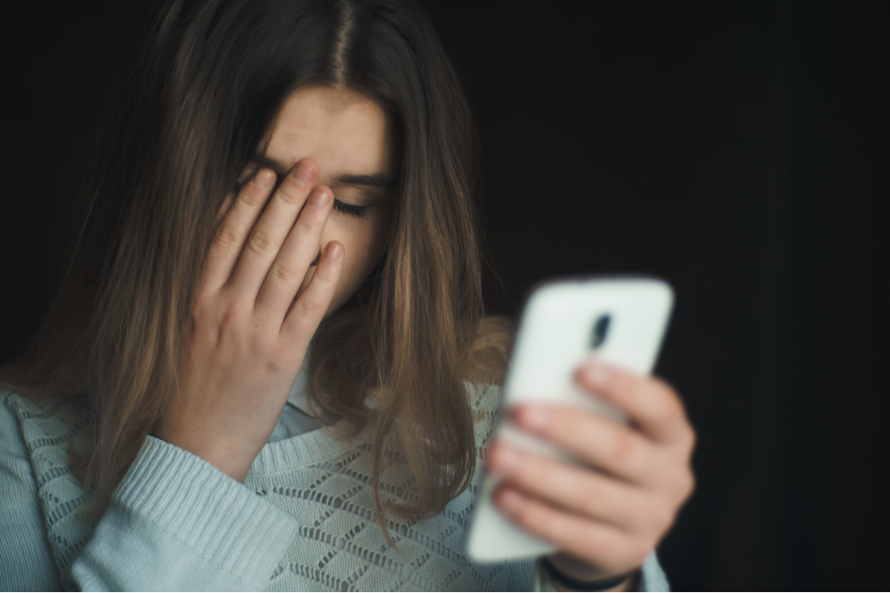 Woman doomscrolling on her phone, worried about social media and mental health