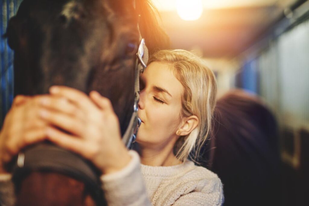 a person hugs a horse after learning the benefits of using horses for mental health