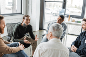 a group of men in a circle talk in a men's addiction treatment center