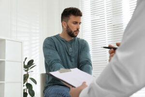 Person with an opioid addiction receiving help from a clinician in painkiller addiction treatment