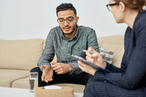 Counselor and client sitting on comfortable couches discussing compsych rehab insurance coverage