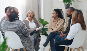 Group of diverse people in group counseling session with therapist at an ecstasy addiction treatment center