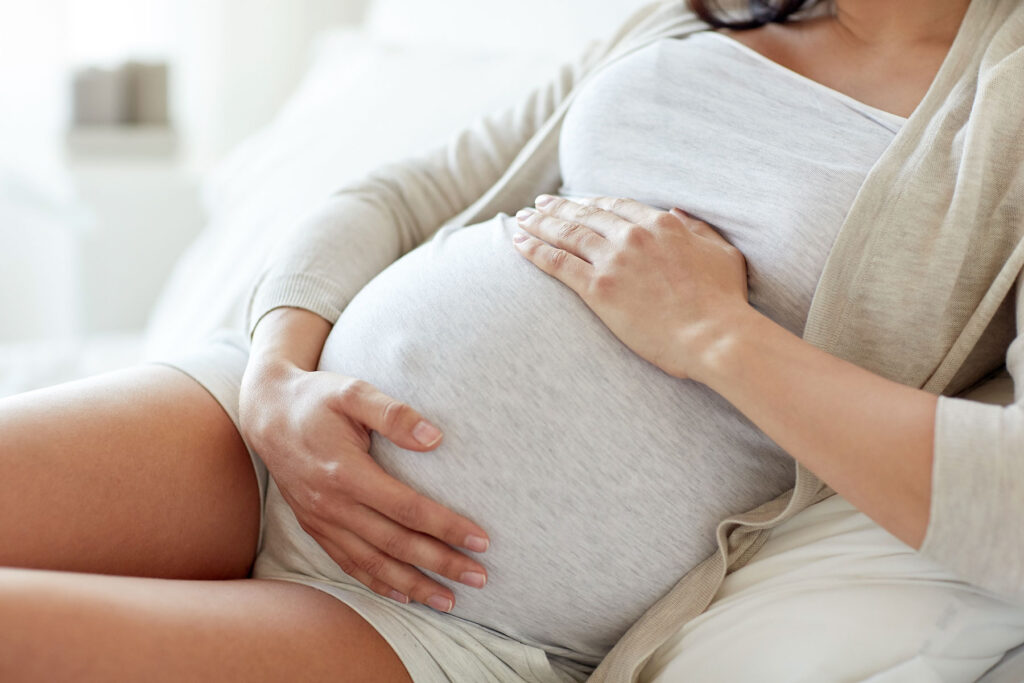 pregnant woman holding belly while wondering can you detox while pregnant