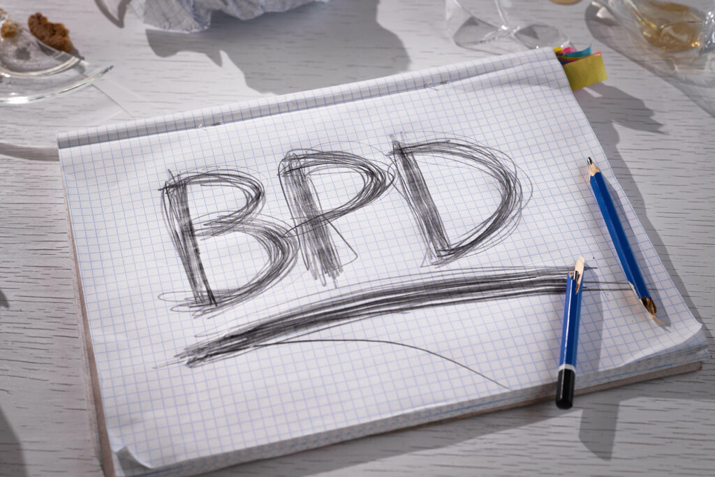 bpd written on notebook paper with broken pencil to illustrate the question what are the symptoms of BPD in women