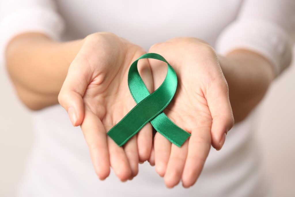 person holding green ribbon during mental health awareness month