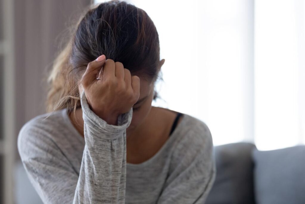 person hanging head with fist on forehead while dealing with ocd triggers