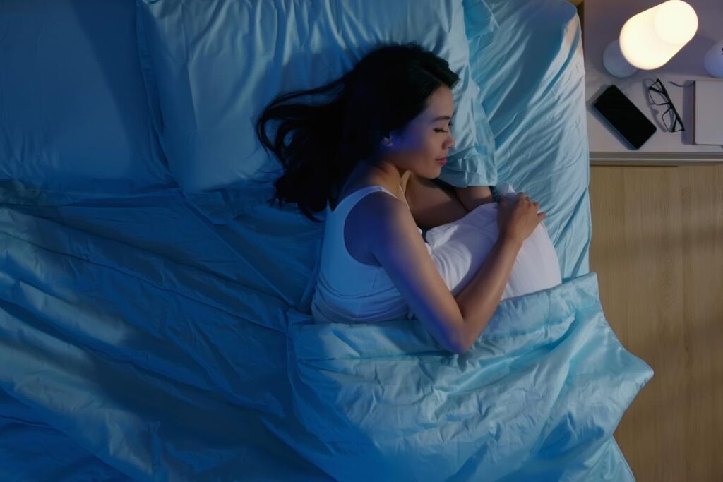 person in bed getting some rest after learning about the connection between sleep and addiction recovery