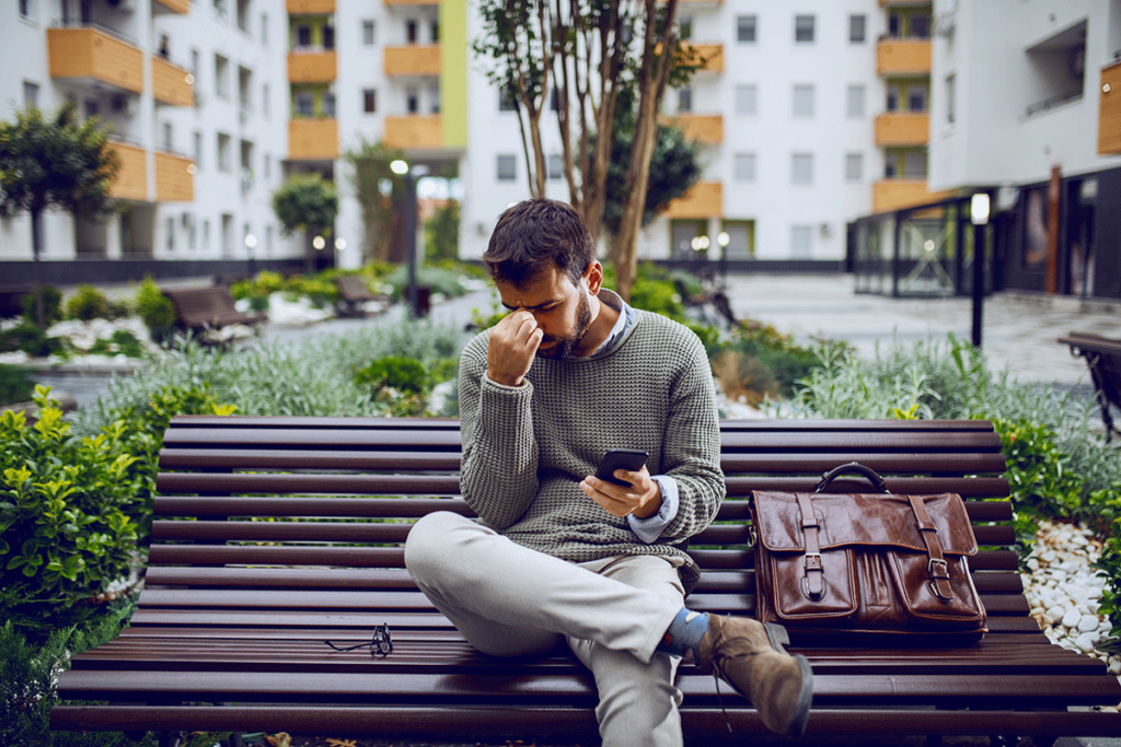 person sitting on park bench hanging head while struggling with adhd and bipolar disorder