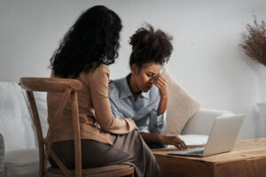 concerned person sitting down with person struggling while talking about morphine addiction treatment