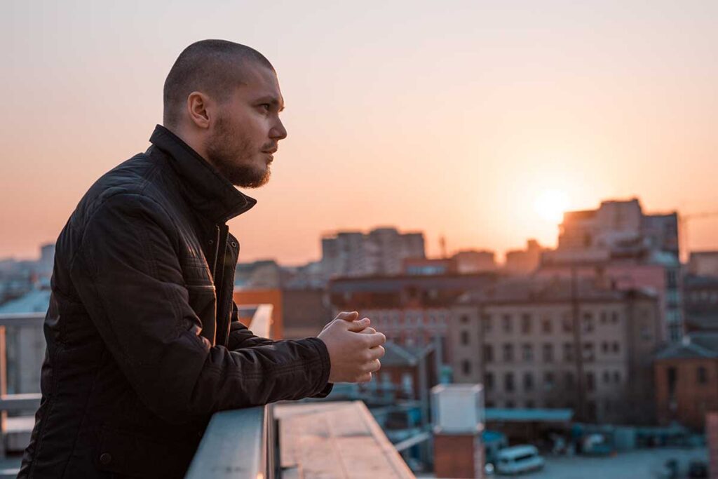 person on rooftop at sunset trying to relax while dealing with acute stress disorder vs ptsd