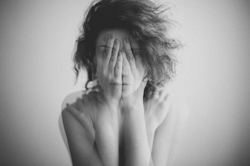 person covering face and experiencing disorientation while struggling with anxiety disorders