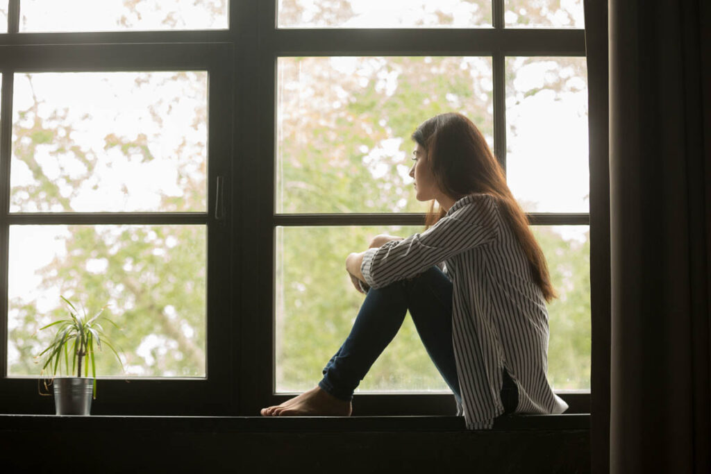 person sitting by window after learning about trauma and codependency