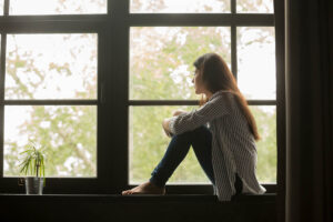 person sitting by window after learning about trauma and codependency